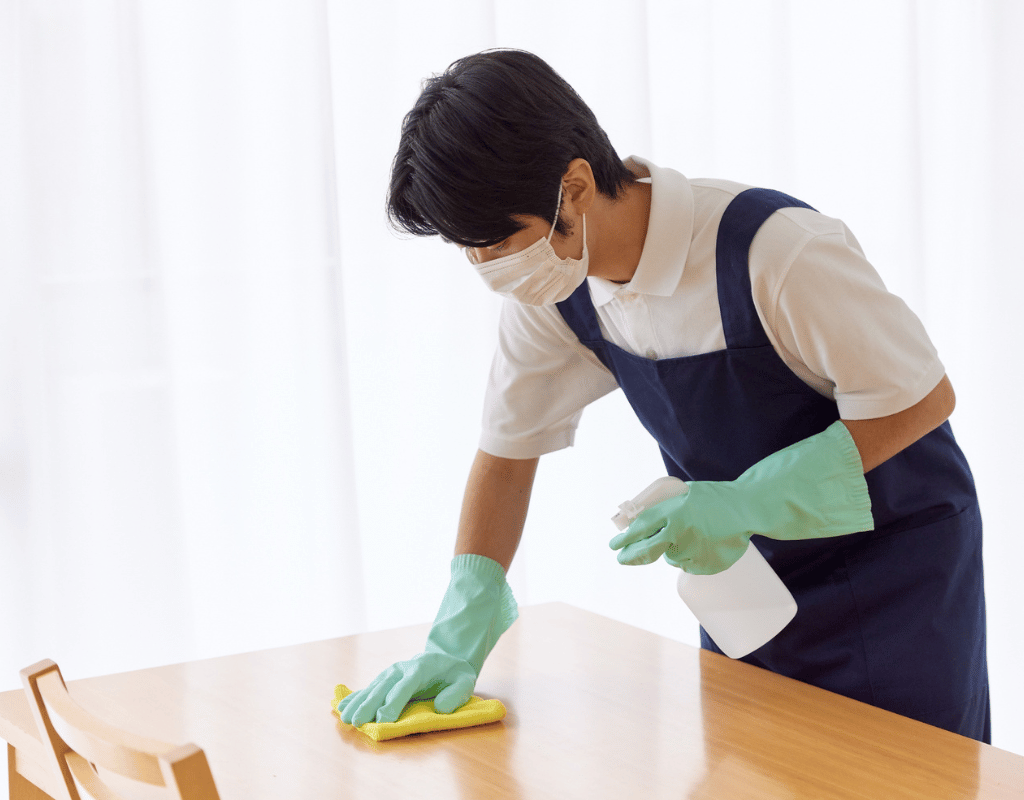 Move-out cleaning service with masked cleaner sanitizing surfaces before turnover in New Castle County DE