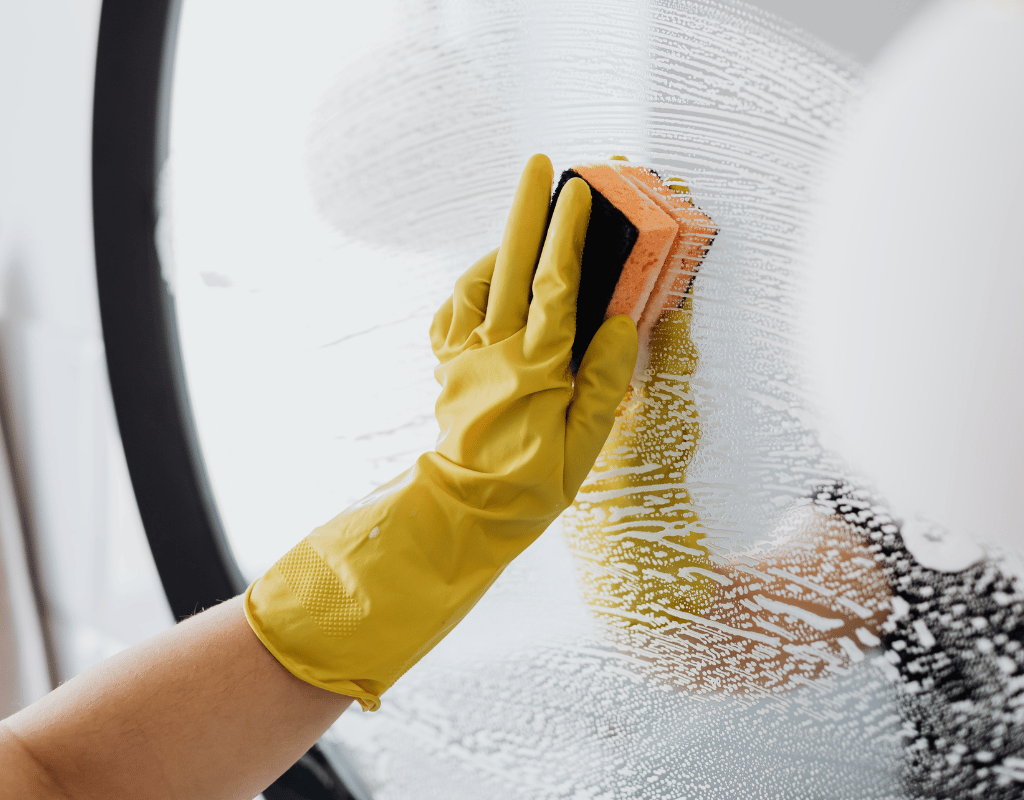 Standard cleaning service with sponge wiping glass for a fresh home in New Castle County DE