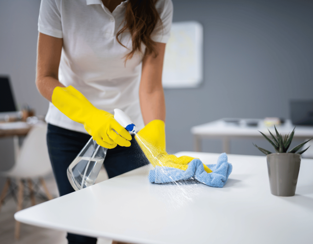 Student apartment cleaning with disinfecting spray and cloth for clean living spaces